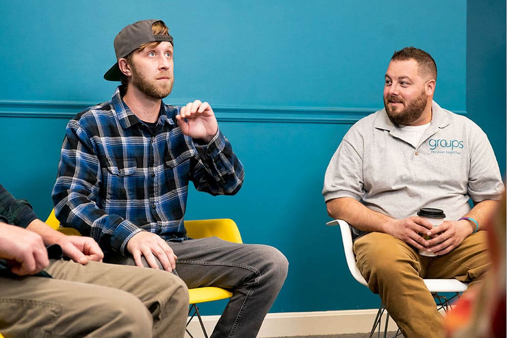 Groups member Ben talks to counselor Myles in group